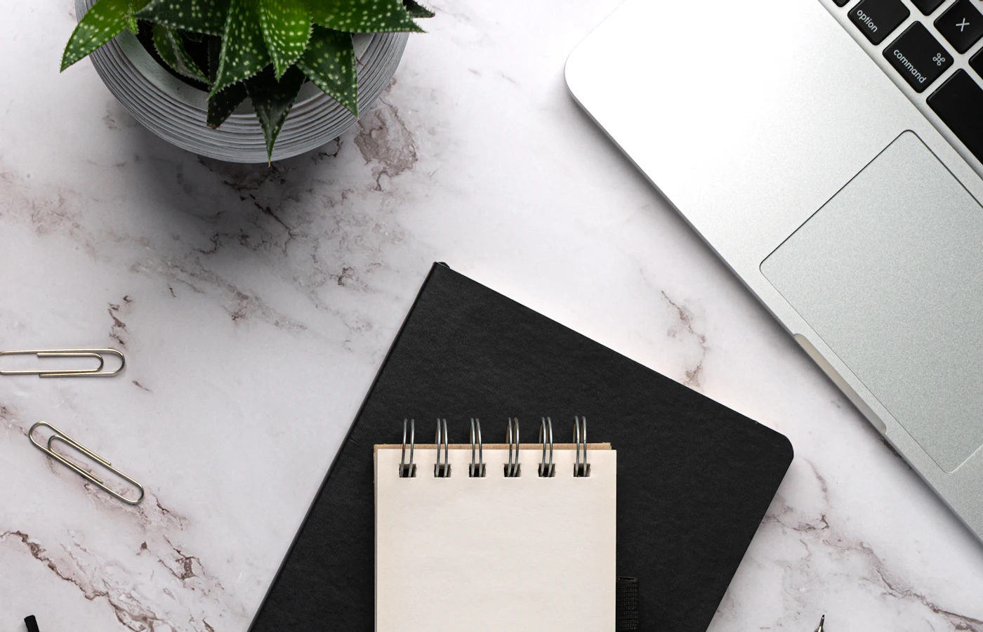 Notebook, pen, glasses, and laptop arranged for employment research